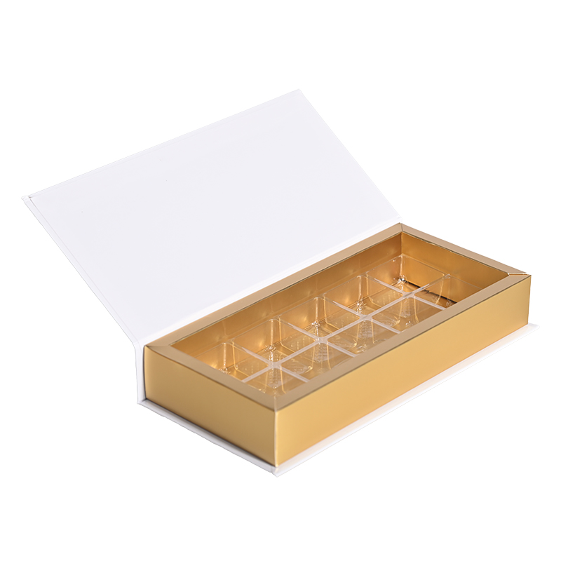 Offene, elegante Pralinenschachtel mit weißem Magnetdeckel, goldfarbenem Boden und einem durchsichtigen 10‑Fach-Blister-Einsatz für einzelne Pralinen.